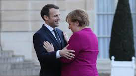 abbraccio tra Merkel e Macron